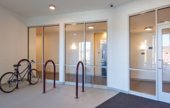 a hallway with glass doors and a bike in the corner