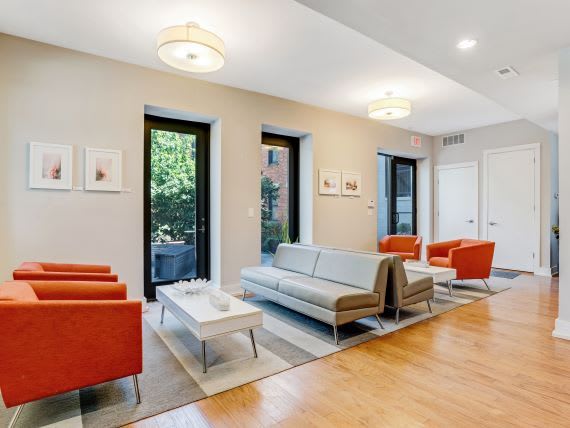 a living room with orange chairs and a white couch