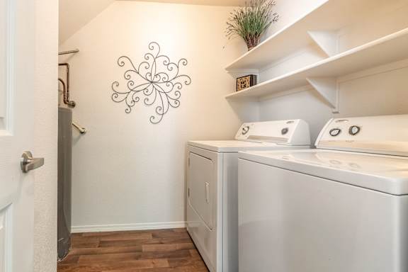 A white wall with a black decoration and a washing machine.