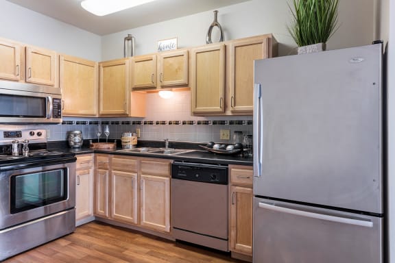 a kitchen with stainless steel appliances and wooden cabinets