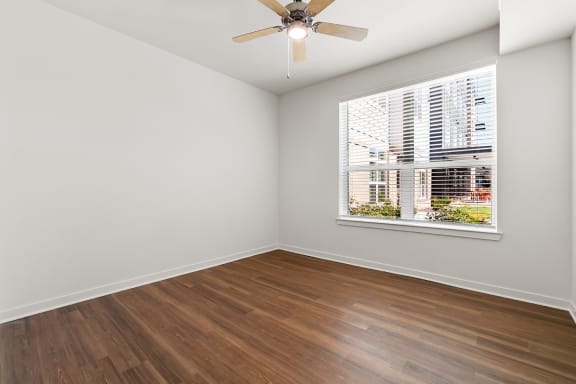 an empty room with a window and a ceiling fan at South City Senior Apartments in Memphis, TN