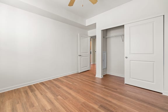 an empty bedroom with white walls and a door to a closet at South City Senior Apartments in Memphis, TN