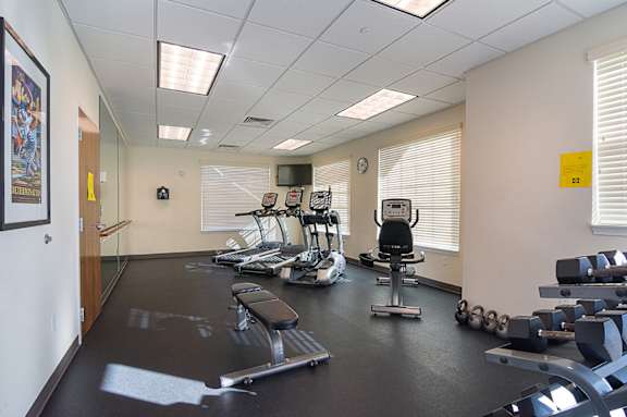 A gym with a variety of equipment including weights and a treadmill.