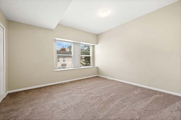 an empty room with carpet and a window