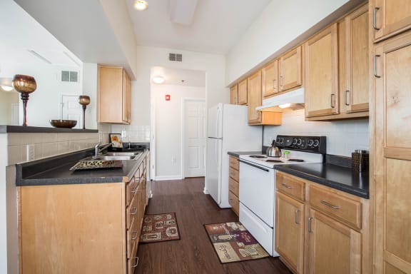 a kitchen with white appliances and wooden cabinets