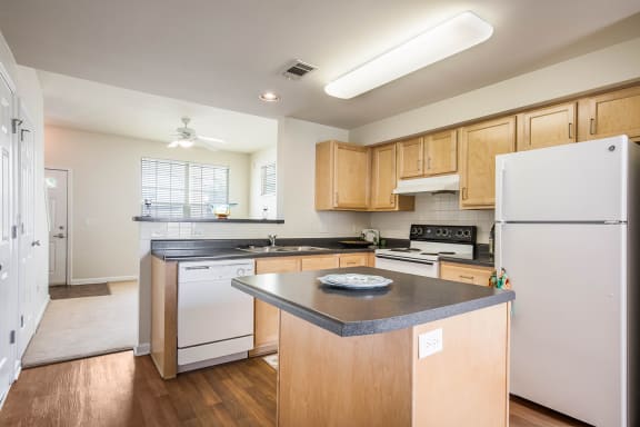 a kitchen with white appliances and wooden cabinets