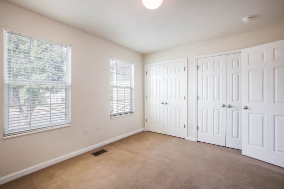 an empty living room with two doors and a window