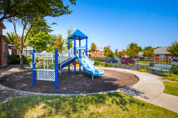 a blue playground with a blue slide in a park