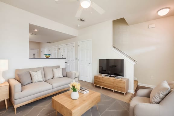 a living room with couches and a coffee table and a television