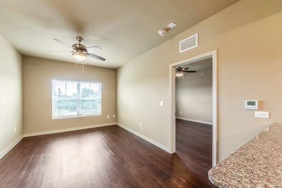 an empty living room with wood floors and a ceiling fan at Wheatley Park Senior Living San Antonio