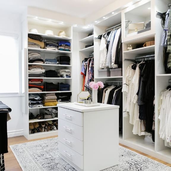 Spacious walk-in closet with with shelves and center isle