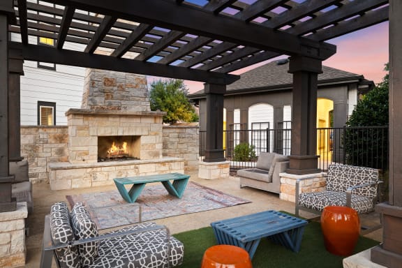 a covered patio with a fireplace and furniture