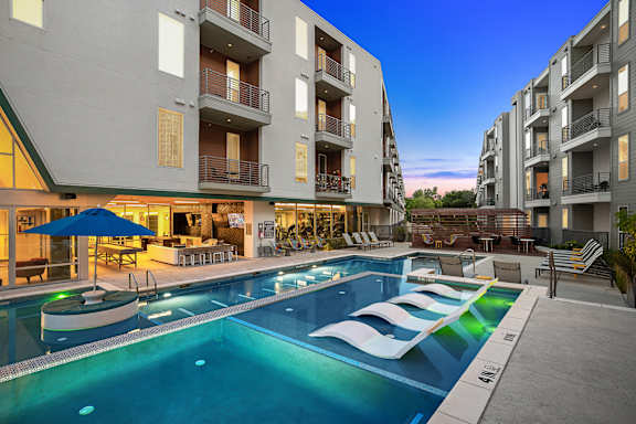 A swimming pool in front of apartment buildings.