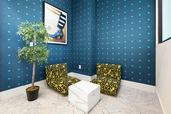 two chairs and a table in a room with a plant