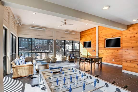 A foosball table is in the middle of a living room.