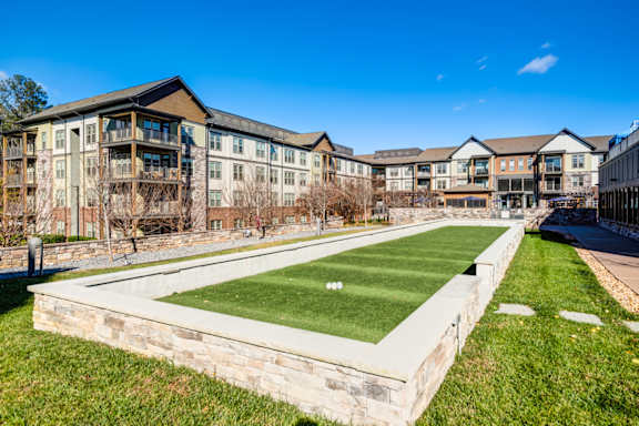 A grassy area in front of apartment buildings.