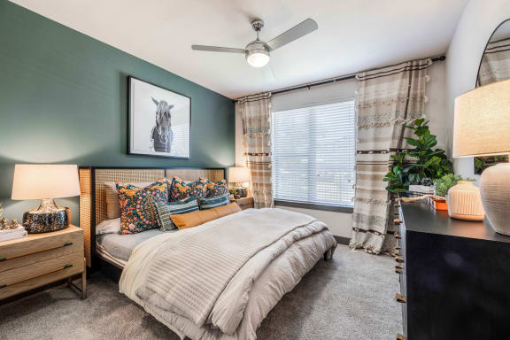 a bedroom with a bed and a ceiling fan