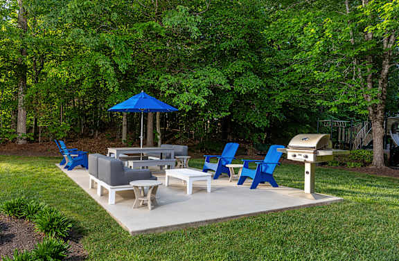 A blue and white outdoor furniture set is placed on a concrete patio.