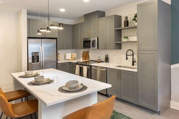 a kitchen with stainless steel appliances and a white table