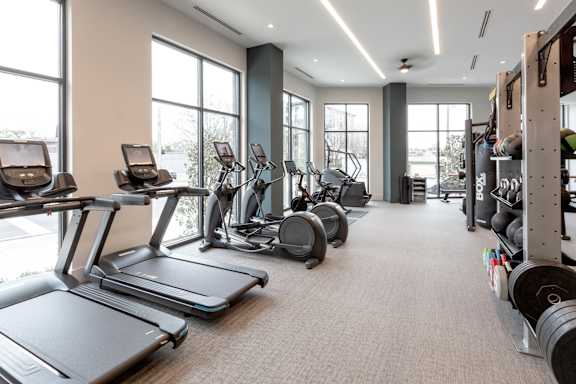 the gym with treadmills and weights at the district flats apartments