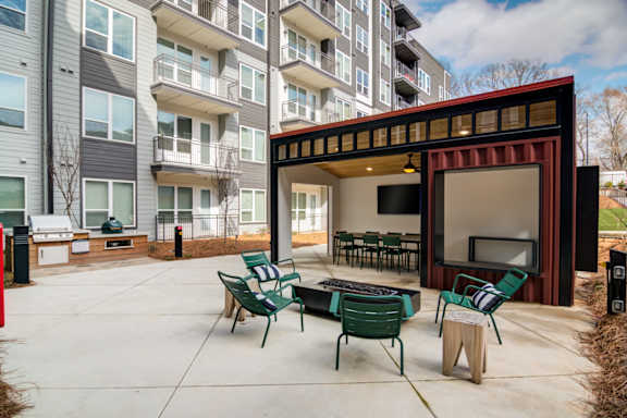 A patio with a table and chairs is in front of a building.