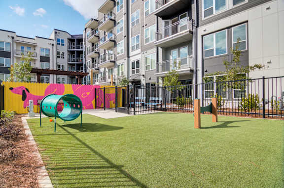 A playground with a slide and a green lawn.