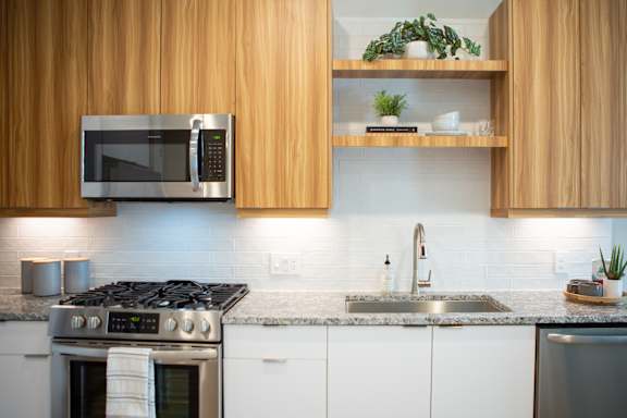 A modern kitchen with a stove, microwave, and sink.