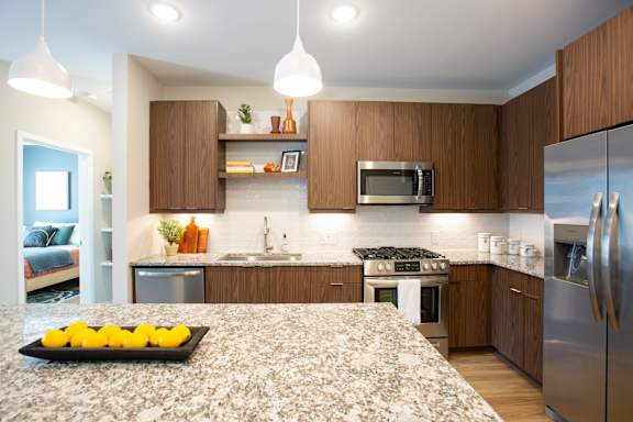 A kitchen with a granite countertop and stainless steel appliances.