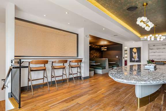 A bar area with a counter and chairs.