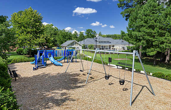 A playground with a blue slide and swings.