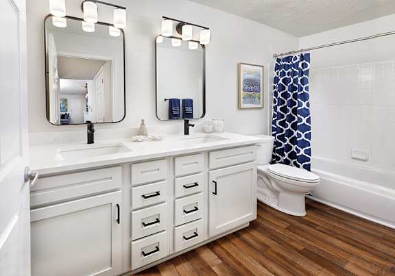 A bathroom with a white sink and a white toilet.