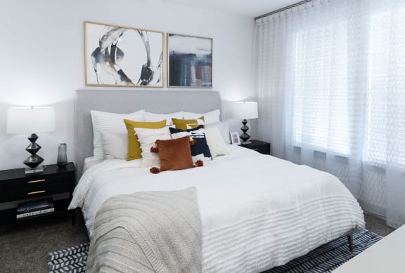 a bedroom with a large white bed and pictures on the wall