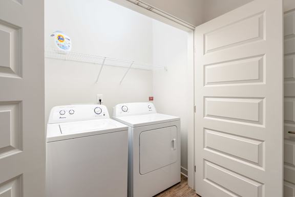 A white washing machine and dryer in a small laundry room.