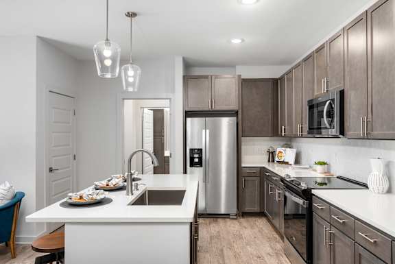 A modern kitchen with a stainless steel refrigerator and wooden cabinets.