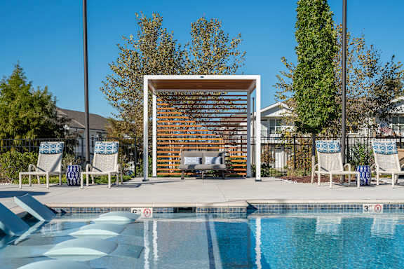 A pool with a slide and a sun shade.