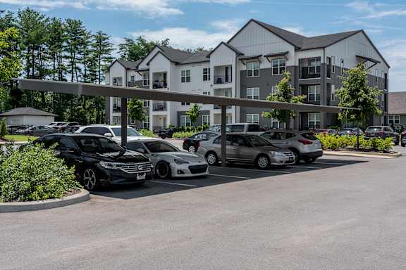 A parking lot with cars and a building in the background.