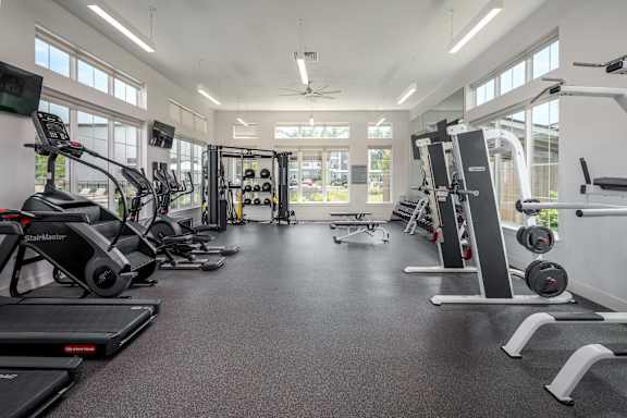 A spacious gym with treadmills, elliptical machines, and weightlifting equipment.