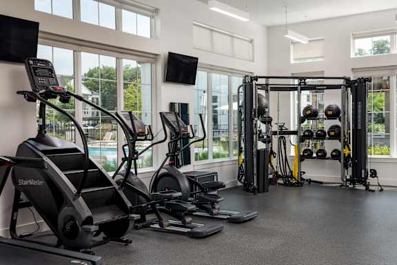 A gym with treadmills, weights, and exercise equipment.
