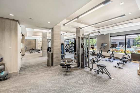 A spacious gym with a variety of equipment and a view of the outdoors.