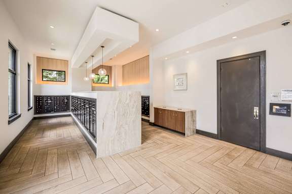 A modern interior with a wooden floor and a black door.