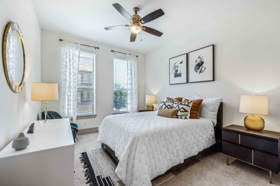 a bedroom with a bed and two windows