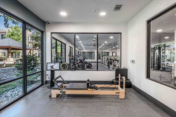 A gym room with a treadmill, weights, and mirrors.