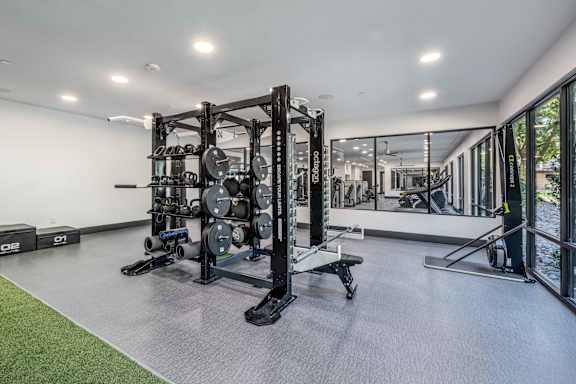 A gym with a weight rack and a bench.