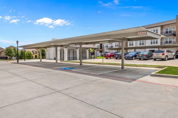 a covered parking lot at the whispering winds apartments in pearland, tx
