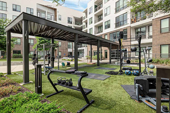 A gym with a variety of equipment is located in a grassy area.