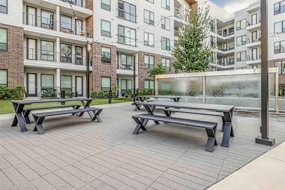 A glass wall separates the seating area from the building.