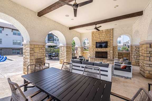A patio with a table and chairs and a television.