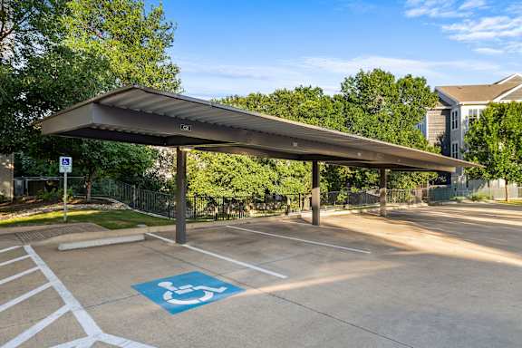 A parking lot with a covered area and a handicap parking space.