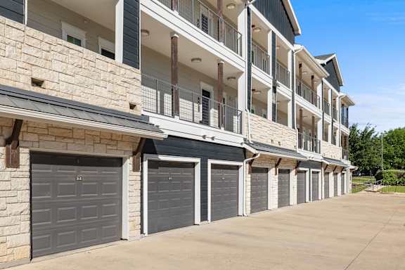 Apartment building with garage doors and balconies.