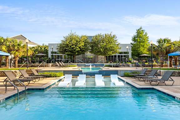 A pool with a slide and sun loungers.
